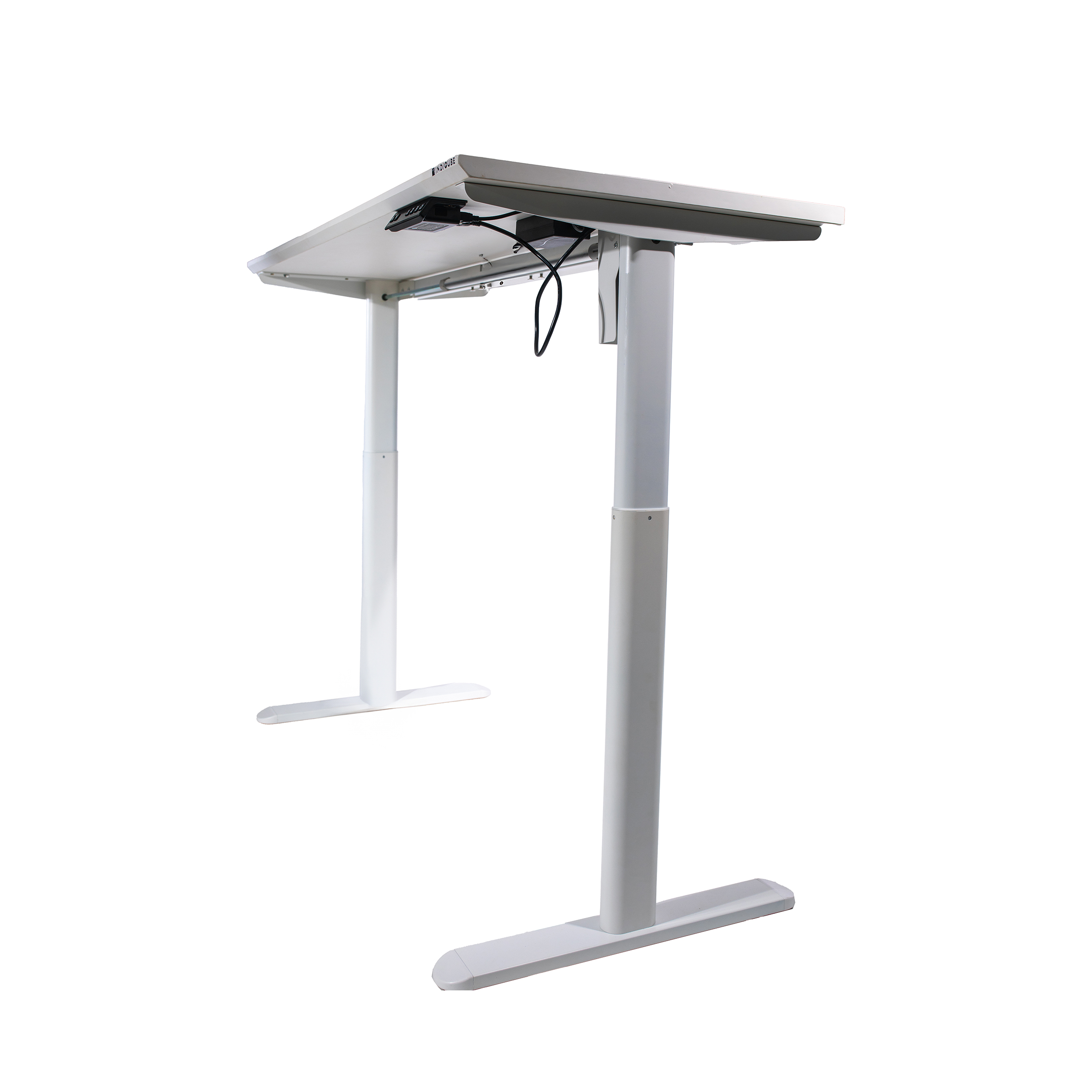 A white adjustable standing desk with a sleek, minimalist design. Two black cords hang from the underside, and the desk stands on T-shaped legs.