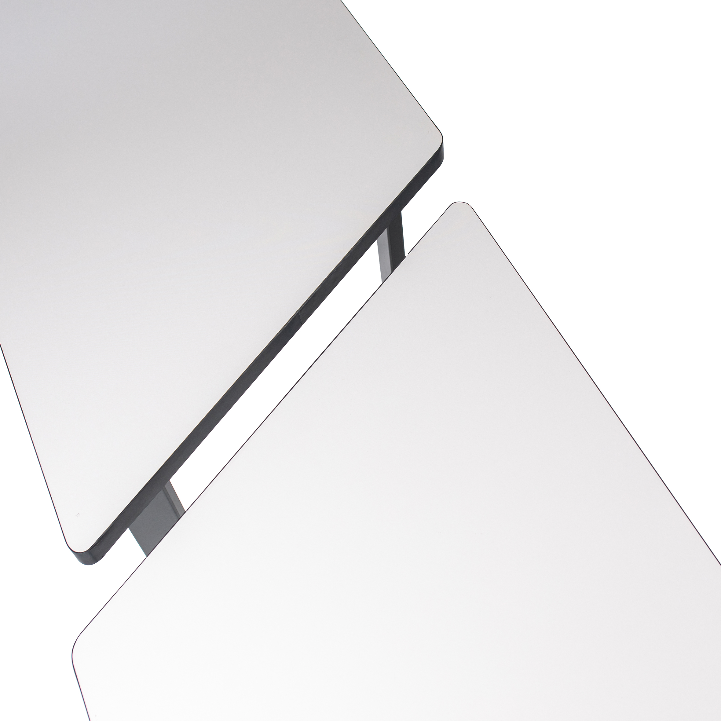 Minimalist trapezoidal table with a white top and four black legs. Two legs have wheels, suggesting mobility. Clean, modern design, suited for versatile use.