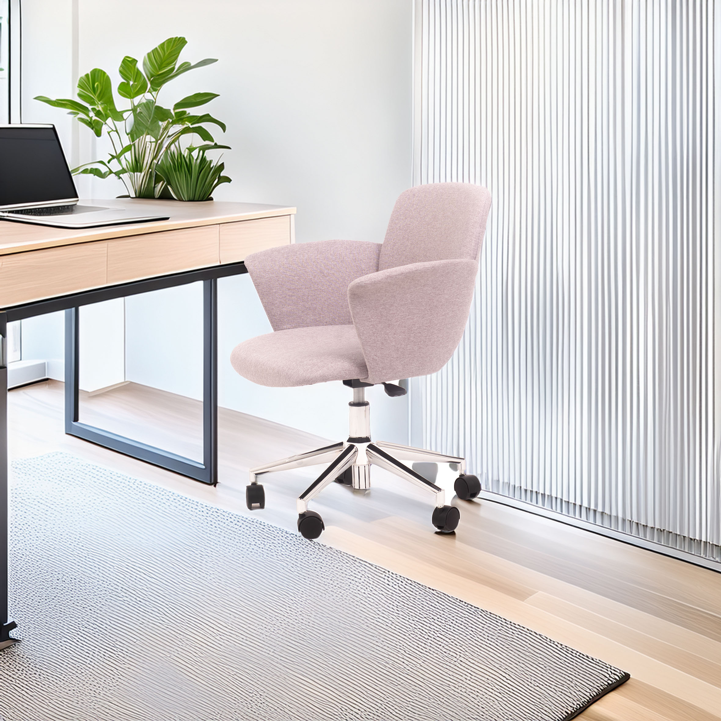 A cozy office chair with grey upholstery sits on a light wood floor near a modern desk with a laptop and green plants, creating a calm workspace vibe